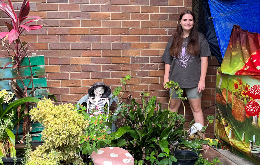 Teenage girl standing in the garden she created 