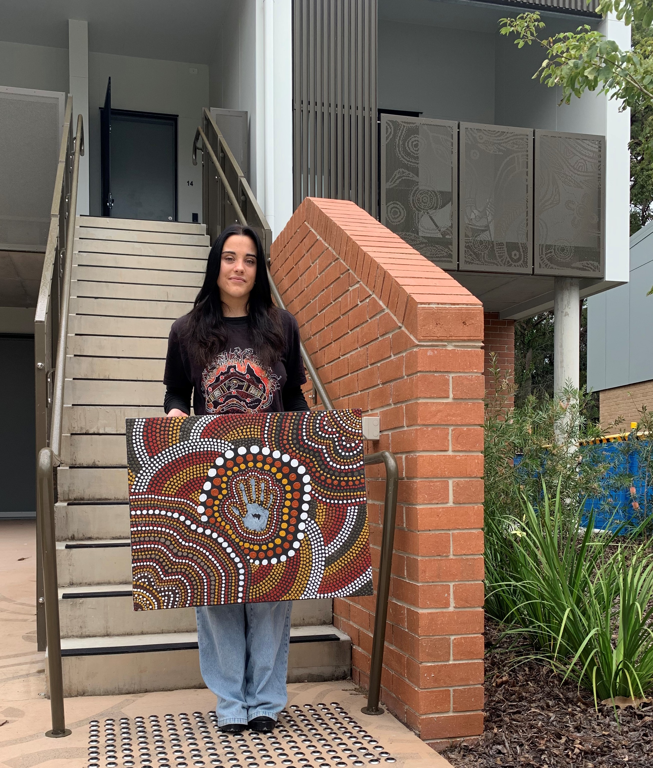 Dani holding Aboriginal painting outside Mari-Mari_ba