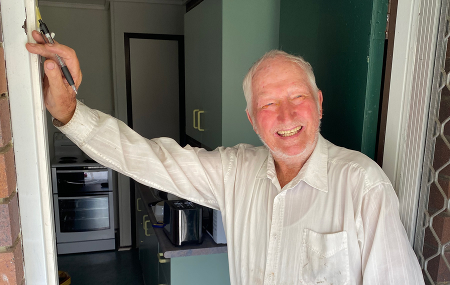 man in entrance of a small social housing complex in Manly